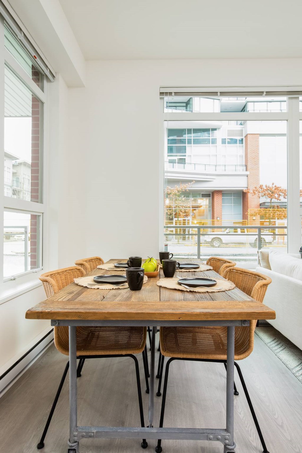 A dining table with chairs and a tablecloth is set for a meal.