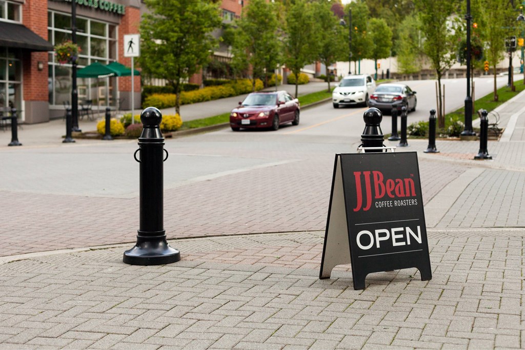 A sign that says JBean Coffee Roasters is on the sidewalk.