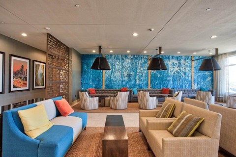 A living room with a blue couch and a brown sofa.