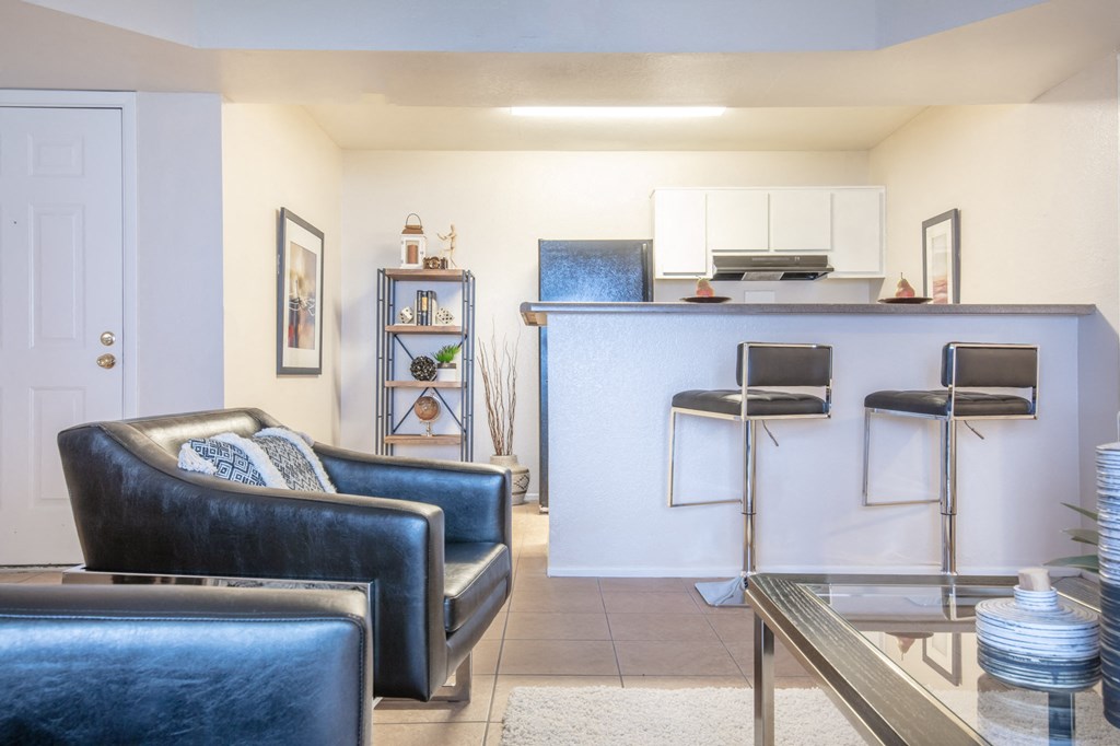 a living room with couches and a bar and a kitchen
