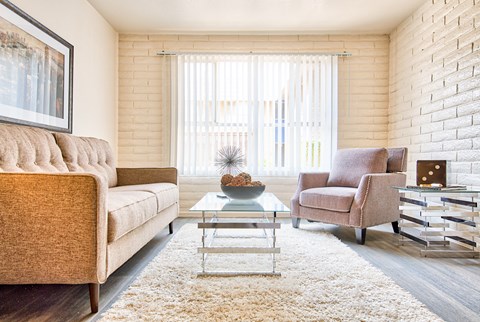 A living room with a sofa, armchair, and coffee table.