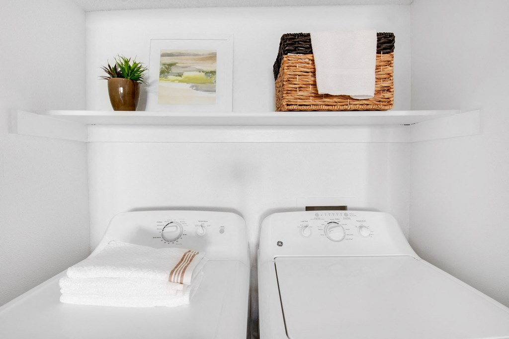 a white washer and dryer in a small laundry room