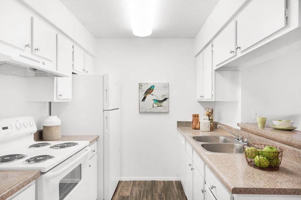 a white kitchen with white appliances and white cabinets