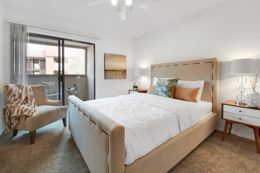 a bedroom with a large bed and a sliding glass door
