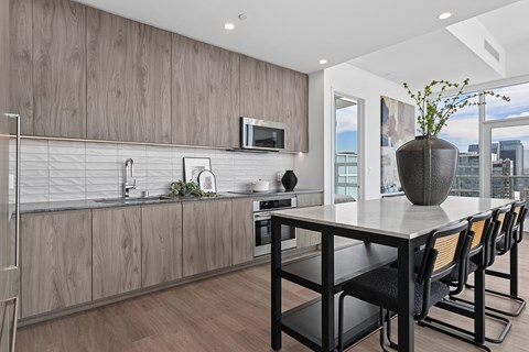 A modern kitchen with a long table and chairs.