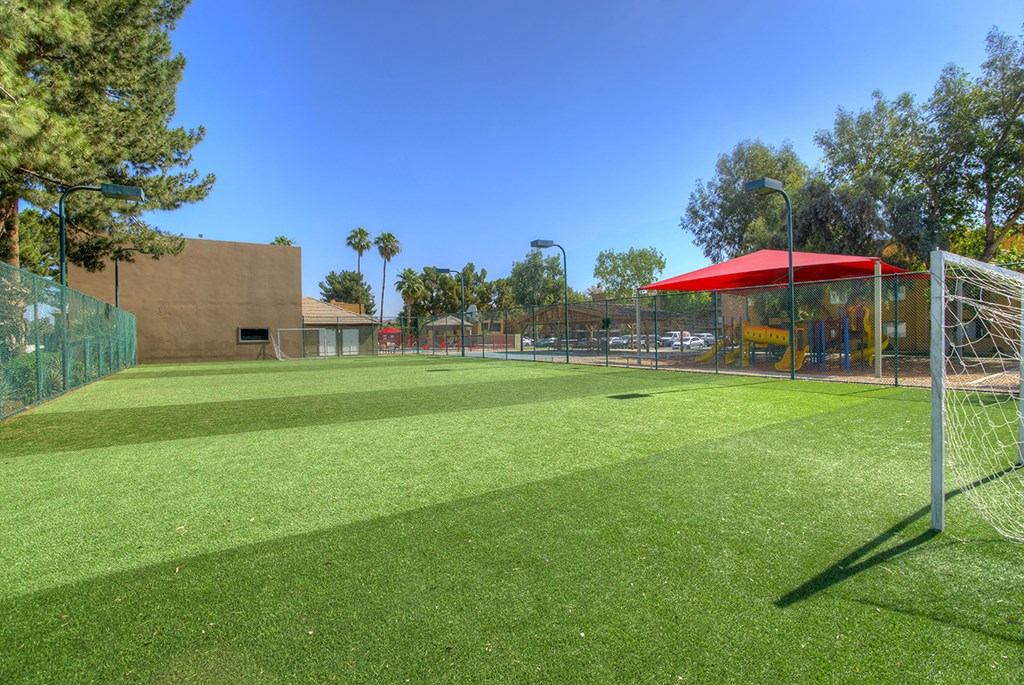 a soccer field with a soccer goal and a playground