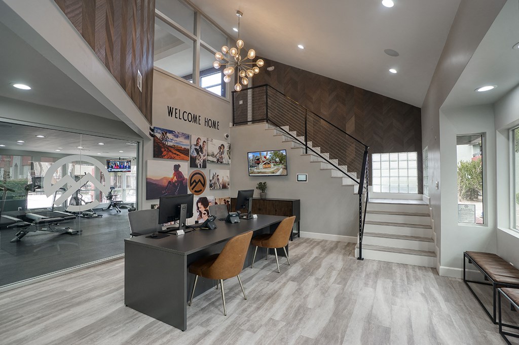 a conference room with a desk and chairs and a staircase