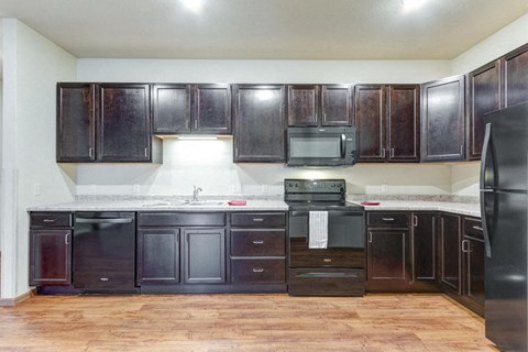 a kitchen with dark wood cabinets and stainless steel appliances