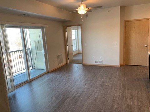 an empty living room with wood floors and a sliding glass door