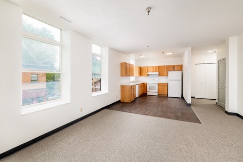 an empty living room and kitchen with a large window