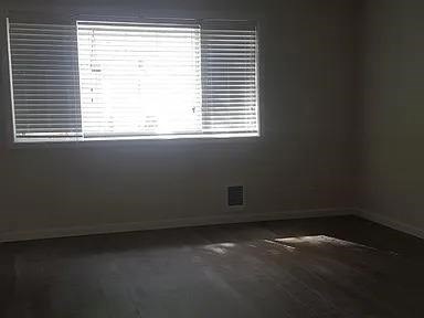 A room with a window covered in blinds.