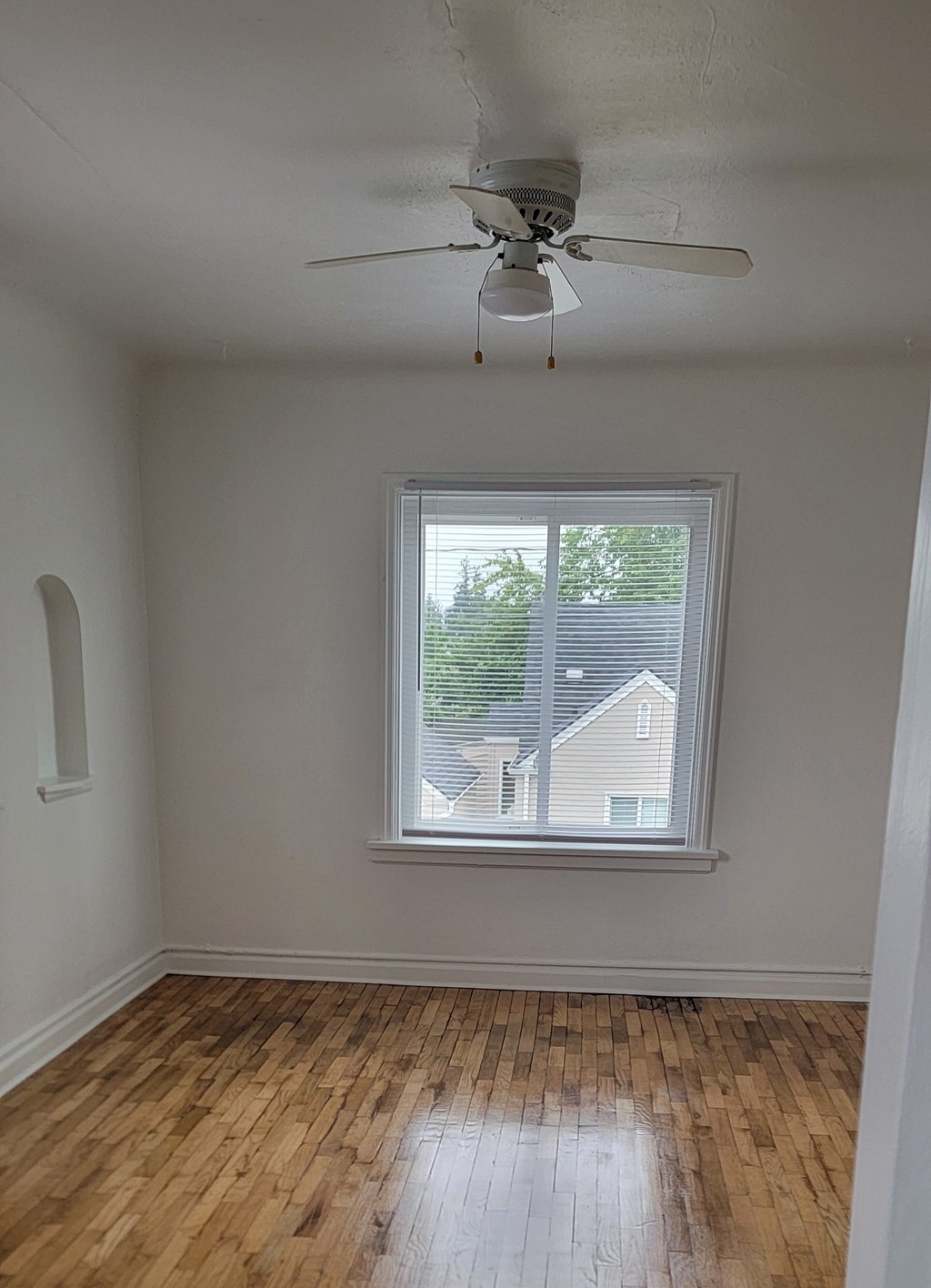 A room with a ceiling fan and a window.