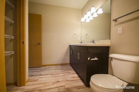 A bathroom with a toilet, sink, and mirror at Spyglass Hill Apartments, Bremerton, WA