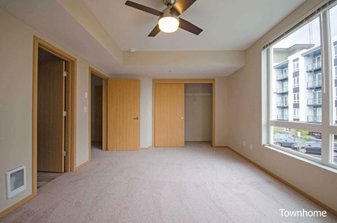 A room with a ceiling fan and carpeted floor at Spyglass Hill Apartments, Bremerton, 98337