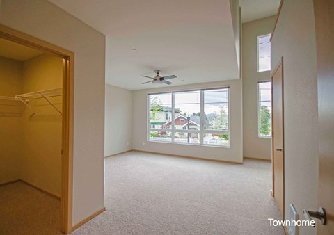 A room with a carpet floor and a ceiling fan at Spyglass Hill Apartments, Bremerton, Washington