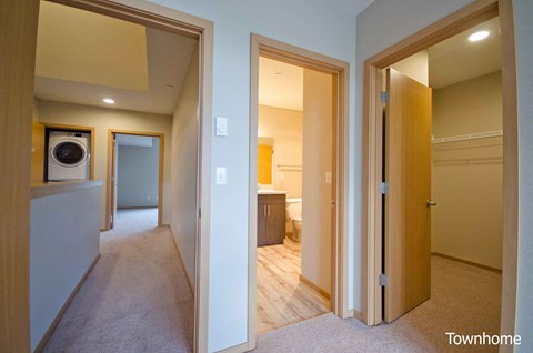 A hallway with a washer and dryer in a home at Spyglass Hill Apartments, Bremerton