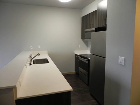 A kitchen with a sink and a refrigerator.