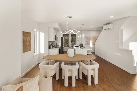 A dining room with a wooden table and white chairs. at The Narrows at Clare Apartments , Bremerton, Washington