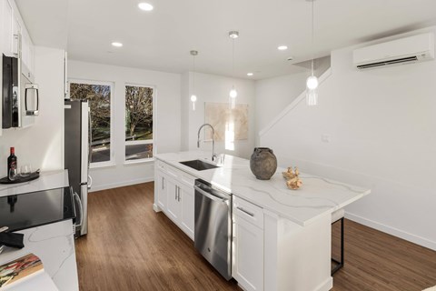 A modern kitchen with white cabinets and stainless steel appliances.