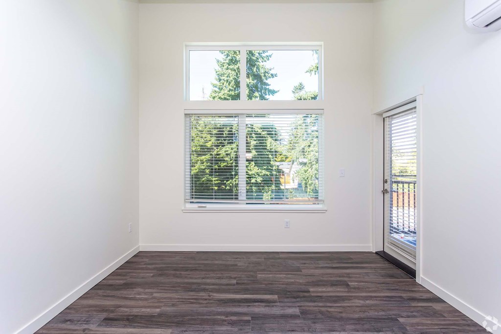 A room with a large window and wooden flooring. at Plisko Place, Port Orchard, WA