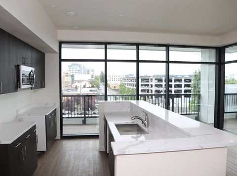 A modern kitchen with a large window overlooking the city.