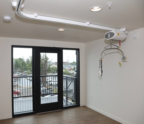 A room with a balcony and a fan on the wall.