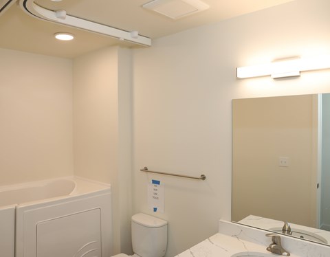 A white bathroom with a toilet, sink, and mirror.