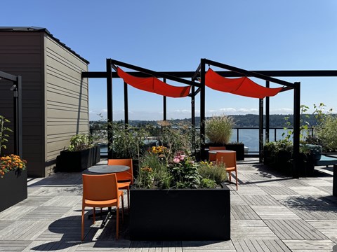 a rooftop terrace with orange chairs and tables at Spyglass Hill Apartments, Washington 98337