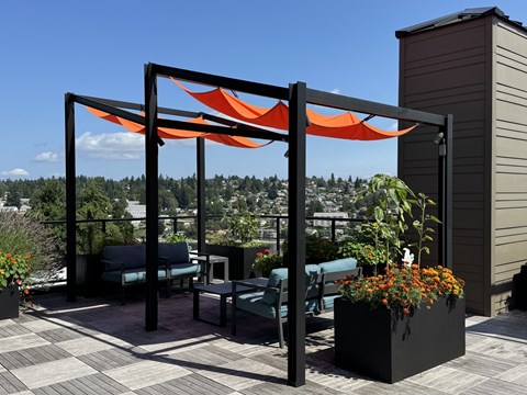 a patio with a canopy and chairs on a roof at Spyglass Hill Apartments, Bremerton, Washington