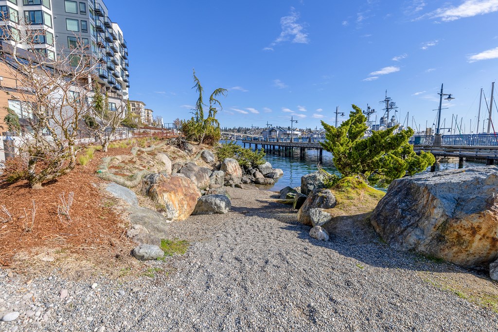 a path leading down to the water with a bridge in the background at Marina Square, Bremerton, 98337