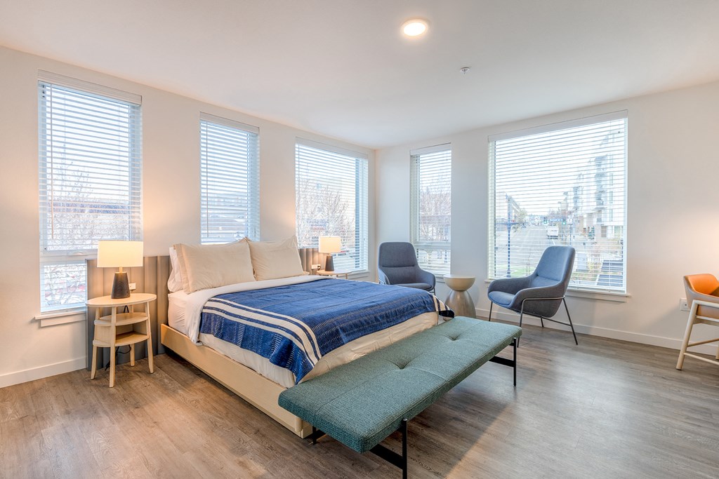 a bedroom with a bed and three oversized windows at Marina Square, Bremerton