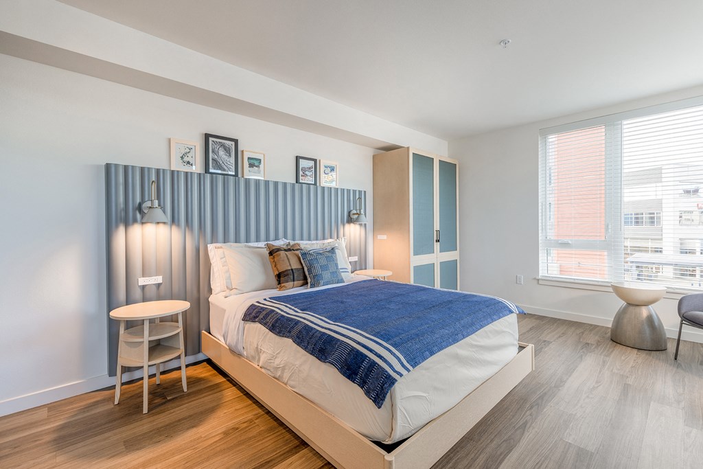 a bedroom with a bed and a chair in front of a window at Marina Square, Washington