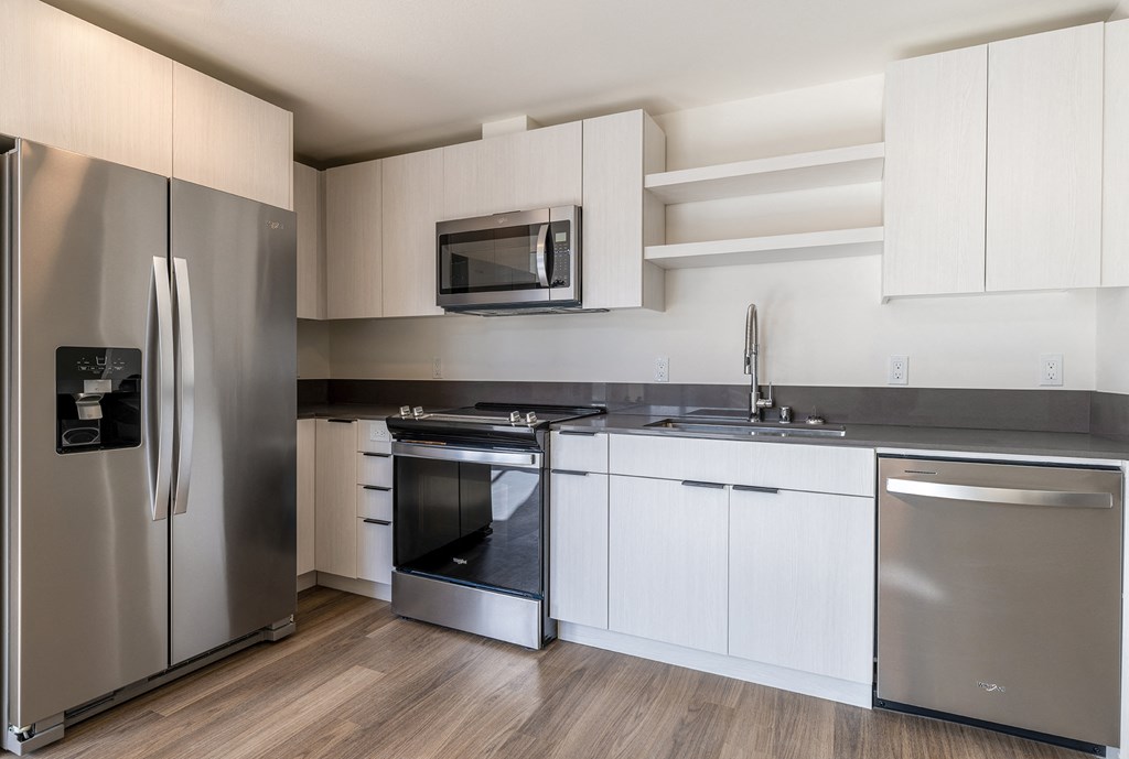 a kitchen with white cabinets and stainless steel appliances at Marina Square, WA 98337