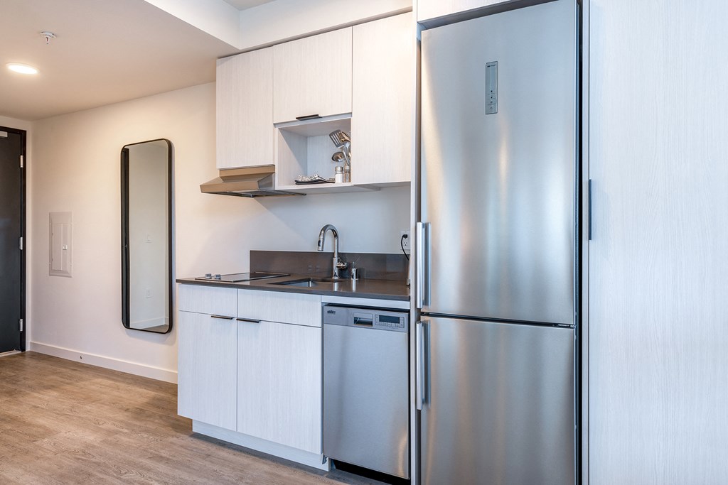 a small kitchen with white cabinets and stainless steel appliances at Marina Square, Bremerton, Washington 98337
