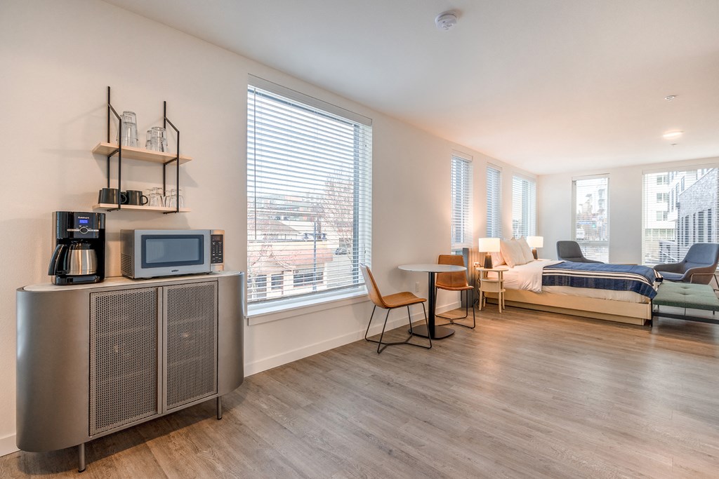 a bedroom with a bed and a tv in a room with a table and chairs at Marina Square, Bremerton, WA