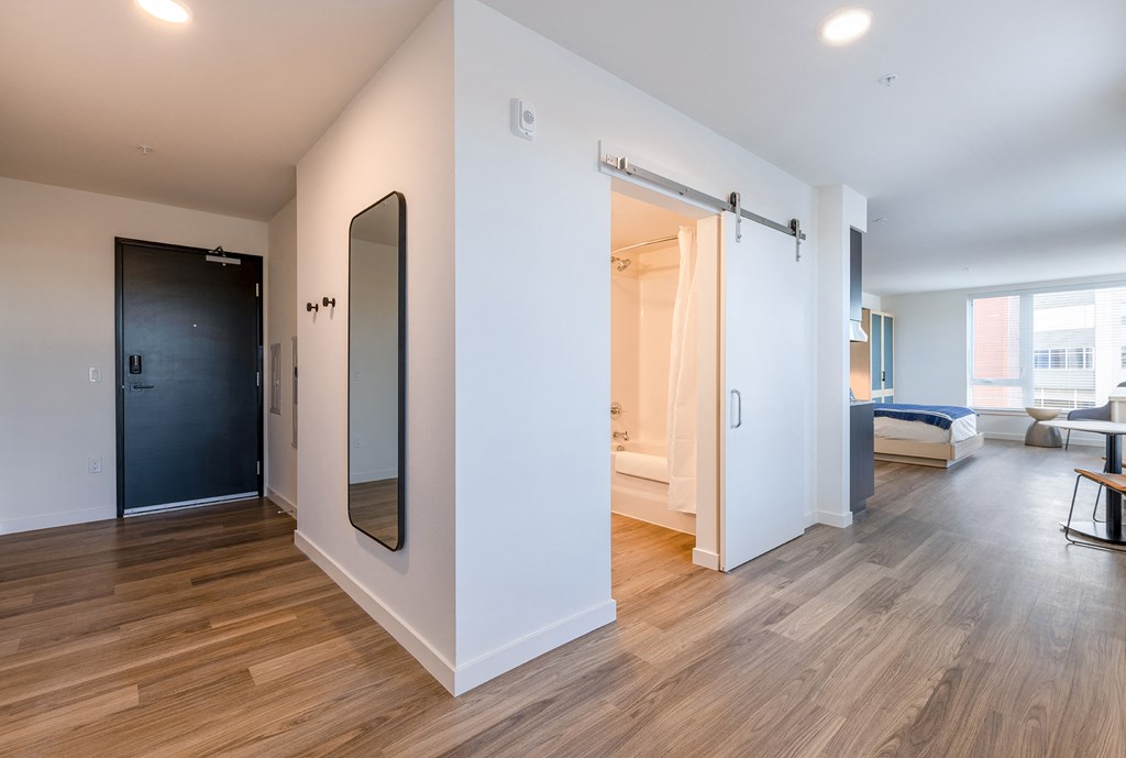 a bedroom with white walls and hardwood floors at Marina Square, Bremerton, 98337