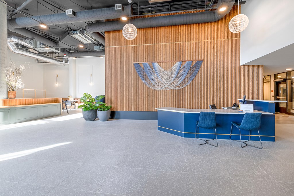 a large open office space with a wooden wall and a blue desk with blue chairs at Marina Square, Bremerton, WA