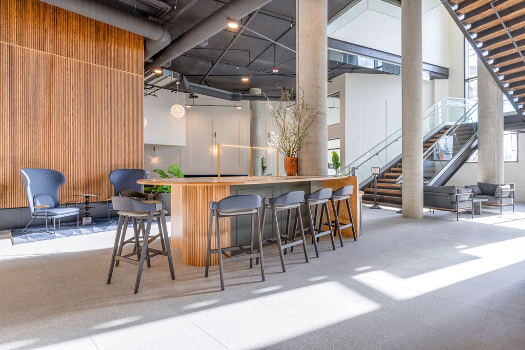 a bar area with stools and chairs and a staircase in the background at Marina Square, Bremerton
