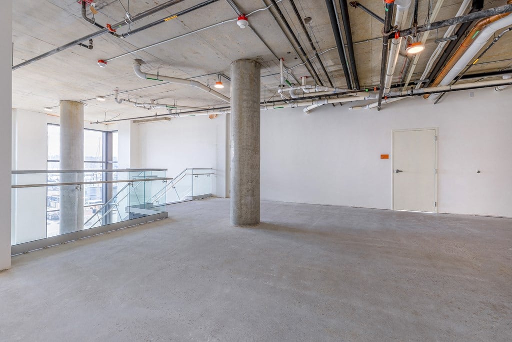 a large room with concrete floors and exposed pipes at Marina Square, Bremerton