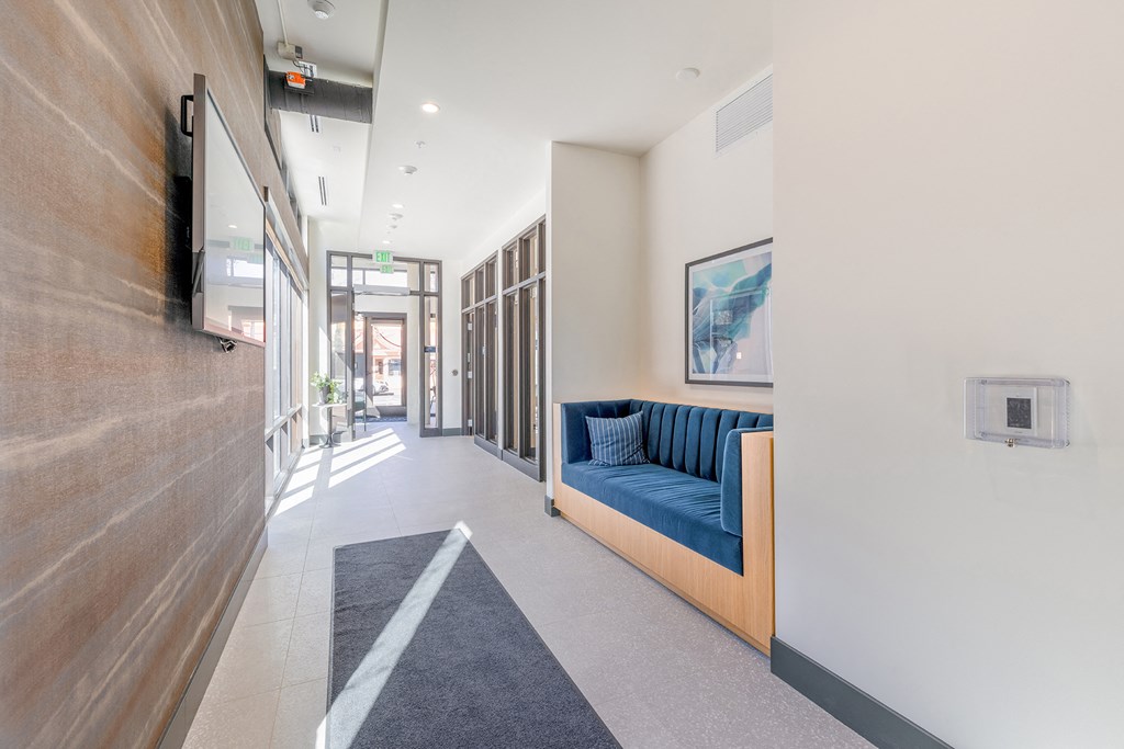 a long corridor with a blue couch on the left and a tv on the right at Marina Square, Washington, 98337