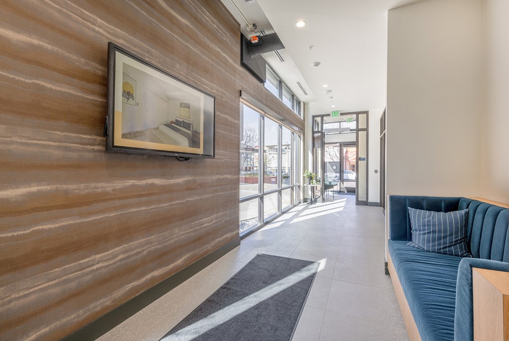 Hallway lobby with artistically textured walls and blue velvet loveseat at Marina Square, Bremerton