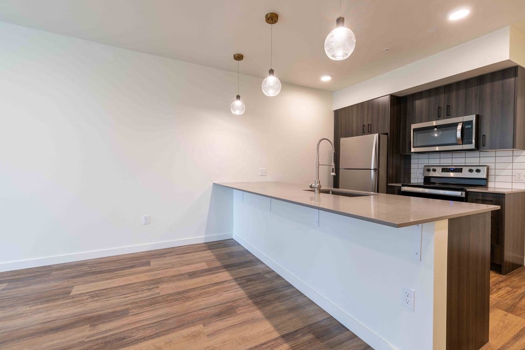 a kitchen with an island and a stove and a refrigerator at Rivulet, Silverdale, 98383