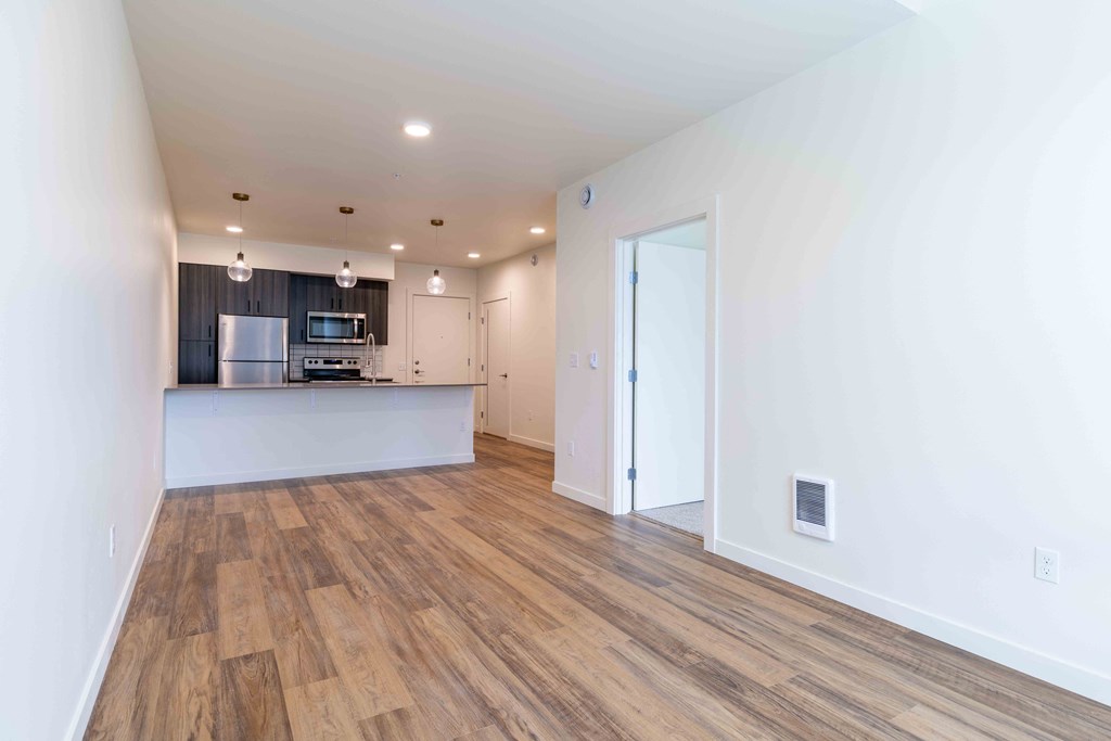 a living room and kitchen with a wood floor and white walls at Rivulet, Silverdale, 98383