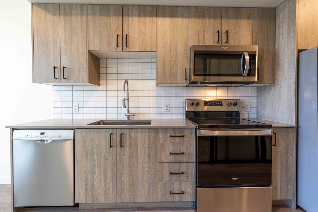 a kitchen with wooden cabinets and a stove and a microwave at Rivulet, Silverdale Washington