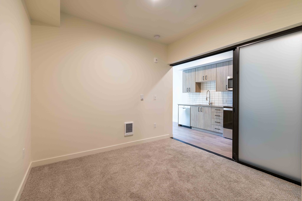 a room with a door to a kitchen and a carpeted floor at Rivulet, Washington, 98383