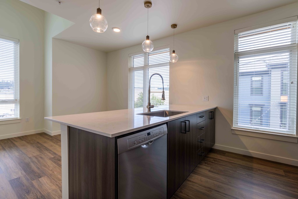 a kitchen with a large island and two windows  at Rivulet, Silverdale, WA, 98383