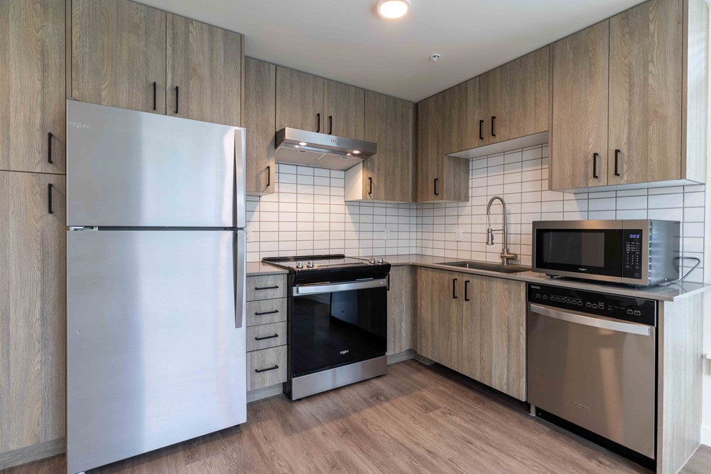 a kitchen with stainless steel appliances and wooden cabinets at Rivulet, Silverdale, 98383