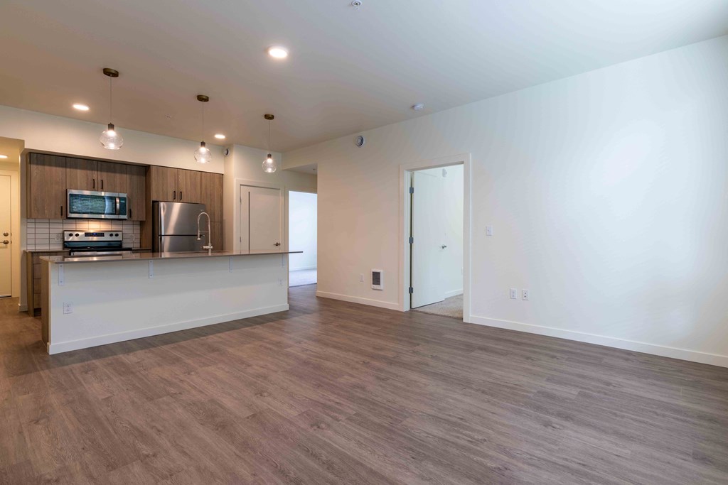 an empty living room with a kitchen and a counter top at Rivulet, Washington, 98383