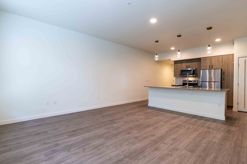 an empty living room with a kitchen and a counter top at Rivulet, Washington