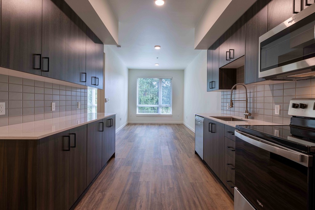 a kitchen with wooden floors and dark cabinets at Rivulet, Washington, 98383